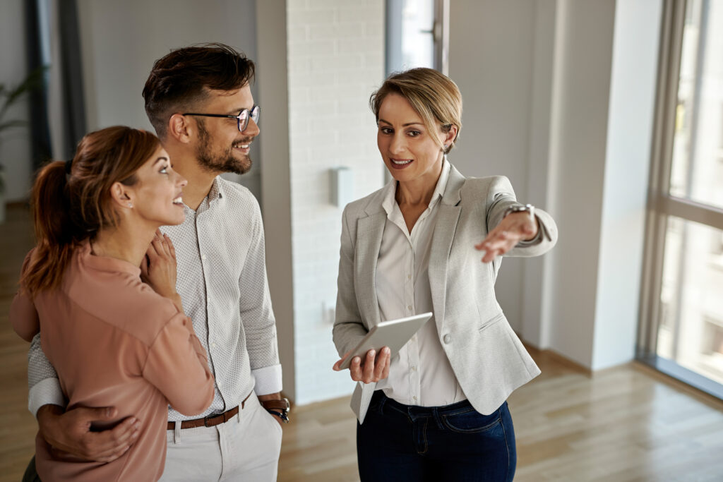 A real estate professional guiding prospective tenants through a walkthrough of a new apartment unit, emphasizing the value of key features.