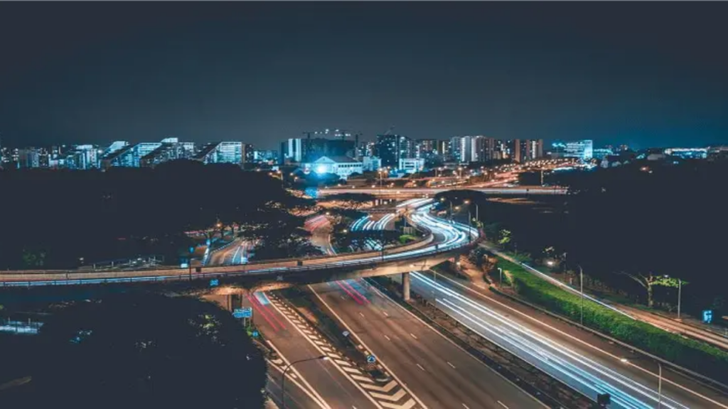 Night-time urban infrastructure view showing residential and commercial real estate corridor development